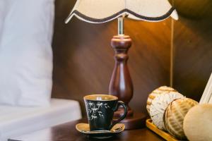 una lámpara y una taza de café sobre una mesa en Hanoi Stella Hotel en Hanói