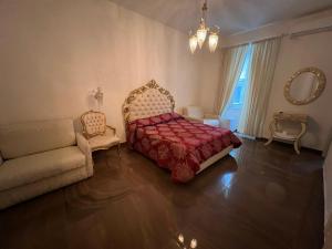 ナポリにあるbeb Mariafrancescaのベッドルーム(ベッド1台、ソファ、鏡付)