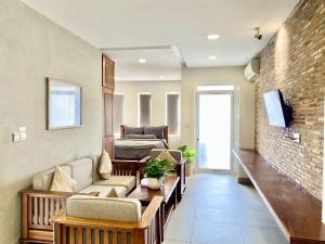 a living room with a couch and a tv at WH Bassac Residence in Phnom Penh