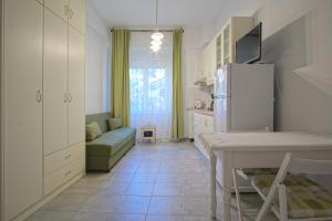 a kitchen with a refrigerator and a table and a couch at Andriana's studio in Parga