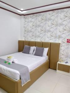 Bett in einem Zimmer mit einer Wand in der Unterkunft D'Mariners Inn Hotel in Batangas City