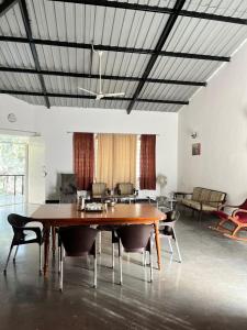 a living room with a wooden table and chairs at Mhaske Farms in Pune