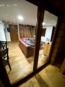 mit Blick auf ein Wohnzimmer mit einem Sofa und einem Spiegel in der Unterkunft Chata TRI GROŠE 2 in Námestovo
