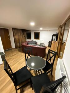 ein Wohnzimmer mit einem Sofa, einem Tisch und Stühlen in der Unterkunft Chata TRI GROŠE 2 in Námestovo
