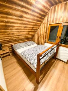 ein Schlafzimmer mit einem Bett in einer Holzhütte in der Unterkunft Chata TRI GROŠE 2 in Námestovo