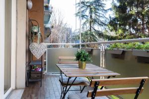 een houten tafel en stoelen op een balkon bij Gattamelata Fiera Lodge in Milaan