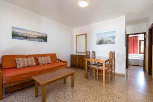 sala de estar con sofá y mesa en Apartamentos Casa del Sol en Cala Blanca
