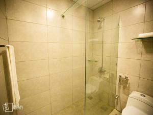 a bathroom with a glass shower with a toilet at Roomy Signature Hotel, Islamabad in Islamabad