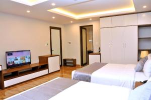 Habitación de hotel con 2 camas y TV de pantalla plana. en An Tín Hotel en Hai Phong