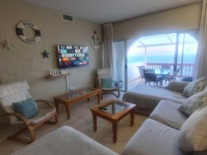 a living room with a couch and a tv in it at Santorini Beach Views - 23 Perissa in Ballito