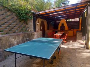 a ping pong table in a patio with a shelter at Forrás Vendégház in Szálka