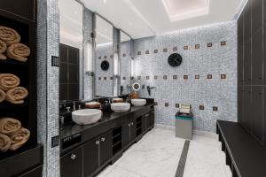 a bathroom with two sinks and two mirrors at Dinamo Hotel Baku in Baku