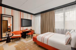 a hotel room with a bed and a desk and a television at Dinamo Hotel Baku in Baku