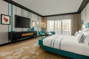 a hotel room with a bed and a flat screen tv at Dinamo Hotel Baku in Baku