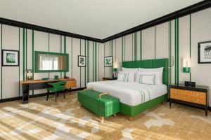 a bedroom with a green bed and a desk and a desk at Dinamo Hotel Baku in Baku