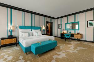 a bedroom with a king sized bed and a desk at Dinamo Hotel Baku in Baku