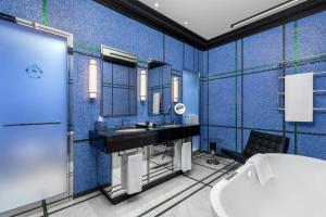 a blue bathroom with a sink and a mirror at Dinamo Hotel Baku in Baku
