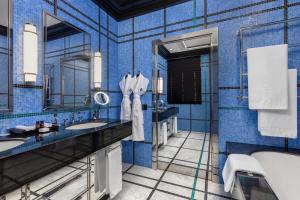 a blue tiled bathroom with two sinks and a tub at Dinamo Hotel Baku in Baku