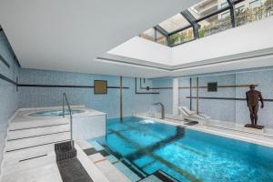 a bathroom with a large swimming pool with a tub at Dinamo Hotel Baku in Baku