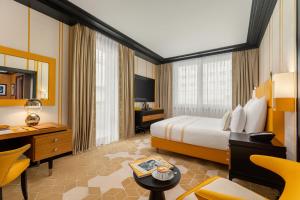 a hotel room with a bed and a desk and a room at Dinamo Hotel Baku in Baku