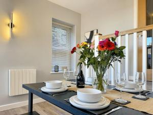 a dining room table with a vase of flowers on it at Harrogate House Apt 3 - 2 Bed Duplex in Harrogate