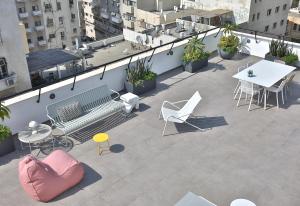 a balcony with a bench and tables and chairs at ROOFTOP 42 - Penthouse in Haifa