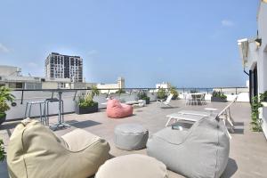 a patio with chairs and tables on a roof at ROOFTOP 42 - Penthouse in Haifa