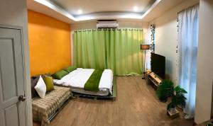 a bedroom with a bed and a green curtain at The Apartium - Modern Apartment Rentals in Bangkok