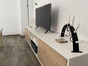 ein Wohnzimmer mit einem Flachbild-TV und einer schwarzen Skulptur in der Unterkunft Alojamiento Rural Los Corrales in Algodonales