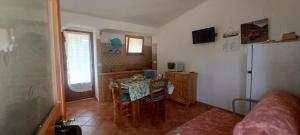 a small kitchen with a table and a refrigerator at Casa Lucia Campagna Relax in Dorgali