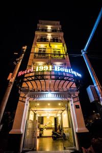 a tall building with a sign on it at night at 1991 Boutique Hotel in Phan Thiet