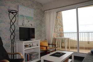 a living room with a television and a balcony at 450 - A ERQUY, en bordure de la très belle plage de CAROUAL in Erquy