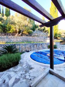 a swimming pool in a backyard with a stone wall at Villa Mir, Igalo, Herceg Novi in Herceg-Novi