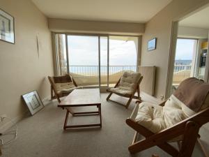 d'un salon avec des chaises et une table ainsi que d'un balcon. dans l'établissement 451 - Appartement à ERQUY, en bordure de la très belle plage de CAROUAL, à Erquy