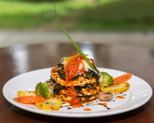 um prato de alimentos com legumes sobre uma mesa em Clover Greens Golf Course and Resort em Sarjāpur