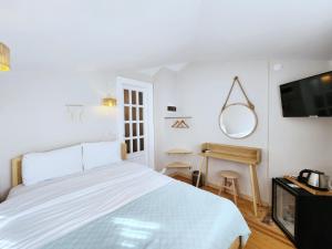 a white bedroom with a bed and a television at Aya Butik Otel in Istanbul