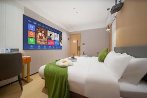 a hotel room with a white bed and a tv at Guangzhou Yashe Hotel - Keyun Road Metro Station Pazhou Convention and Exhibition Store in Guangzhou