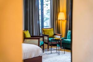 Zimmer mit einem Sofa, einem Stuhl und einem Tisch in der Unterkunft Lemon Lodges By Roomy, Nathiagali in Nathia Gali