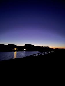 a bridge over a body of water at night at East Learmouth Lakeside Lodges - Larch Lodge in Cornhill-on-tweed
