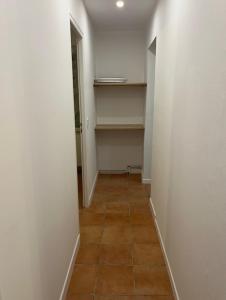 an empty room with a hallway with shelves and a tiled floor at Gite for you muguet in Neuvy-sur-Loire