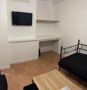 a room with a desk with a television on a wall at Gite for you muguet in Neuvy-sur-Loire