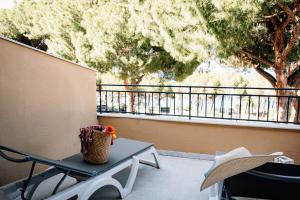 un tavolo e sedie su un balcone con un albero di Al Pescatore a Cefalù