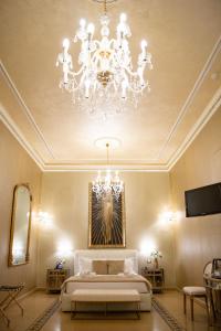 1 dormitorio con cama y lámpara de araña en Contessa Arrivabene Antica Dimora, en Roma
