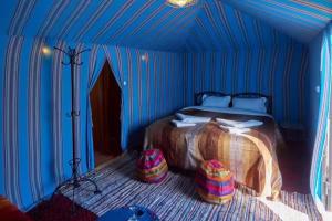 a bedroom with a bed in a blue tent at Berber & Camel Trek in Merzouga