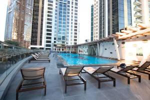 a swimming pool on top of a building with chairs at West Heights 1 - Vacationer in Dubai