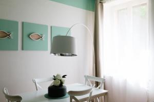 uma sala de jantar com uma mesa e um candeeiro em Appartamento Torrioni - by Casêta em Ancona