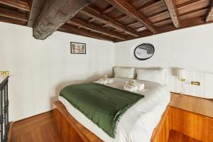 a bedroom with a bed with a green blanket on it at iFlat Magnificent flat near the Colosseum in Rome