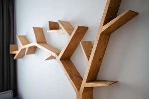 a book shelf made out of wood on a wall at Nr 9 EUROPA22 Apartament bądź Hostel in Tomaszów Mazowiecki
