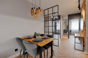 a dining room with a wooden table and chairs at Apartament pod gwiazdką in Tomaszów Mazowiecki