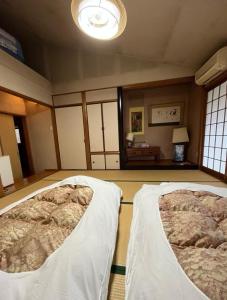 a bedroom with two beds in a room at Homey Inn Enya in Yufu